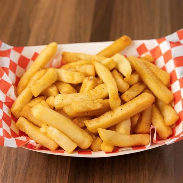 Golden SMA5H fries, seasoned with pepper, in a red and white checkered paper tray.